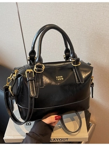 Sleek black Boston handbag with white contrast stitching and gold-tone hardware detail
