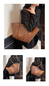 Detail view of brown leather tote bag with FASHION embossed logo and long shoulder straps