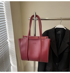 Close-up of wine red tote bag with fashion lettering and precise stitching details