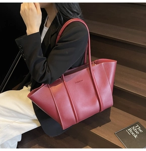 Detail of burgundy leather tote bag featuring 'FASHION' text and large capacity