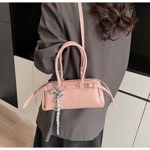 Pink Boston handbag with silver bow charm and heart detail on model's shoulder