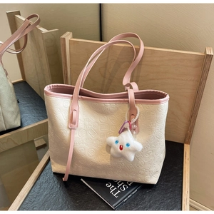 Detailed relief pattern of lotus and coins on a white tote bag with star plush charm