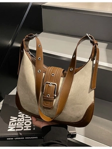 Sac hobo en toile beige avec bordure en cuir marron et boucle métallique sur escalier gris