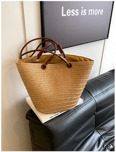 Close-up of the woven texture and premium leather handles on this straw tote bag