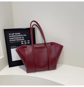 Detail of burgundy leather tote with fashion embossing and refined contrast stitching