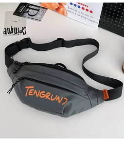 Gros plan du sac bandoulière gris avec lettrage orange et détails de fermeture