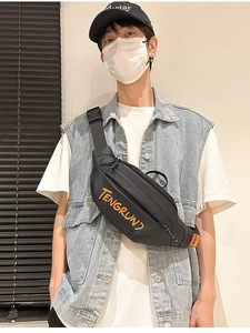 Détail du sac bandoulière noir imperméable avec texte orange porté par un mannequin