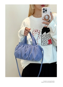 Detailansicht der gefalteten Textur und des lila Stoffes der trendigen Ruched-Cloud-Bag