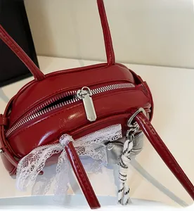 Détail de la fermeture éclair et de la dentelle blanche sur sac en cuir rouge
