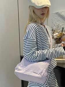 Bolso bandolera de nylon morado claro con diseño plisado y estilo minimalista