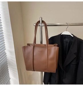 Detail of vintage brown leather tote bag with embossed lettering and fine stitching