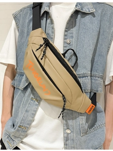 Détail du sac de poitrine kaki avec logo orange et bandoulière réglable en nylon