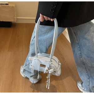 Détail du sac bleu clair avec ruban de dentelle blanche et pendentif argenté