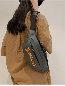 Détail du sac de poitrine gris avec texte orange sur un mannequin en chemise brune