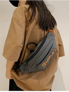Sac bandoulière gris avec broderie orange présenté en vue arrière style streetwear