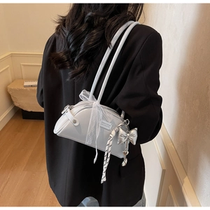 Détails du sac à main gris clair avec nœud en dentelle et breloques argentées