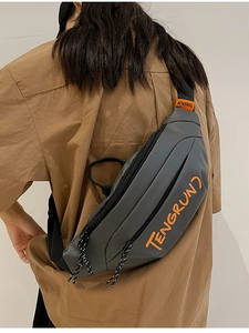 Vue de dos du sac de poitrine gris avec étiquette orange sur une chemise marron