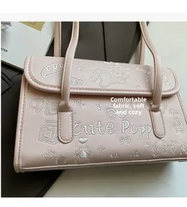 Détail de la texture en cuir PU souple et de la broderie de chiot sur le sac rose