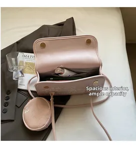 Vue du dessus du sac à bandoulière rose avec compartiment principal et poche zippée