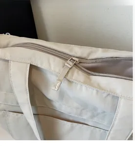 Close-up of smooth zipper closure and textured beige canvas fabric on large tote bag
