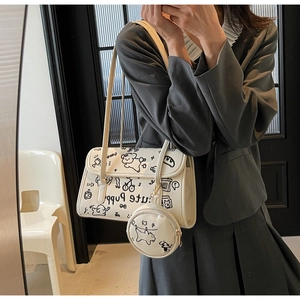 Detalle del bolso blanco con grafiti de cachorros negros y monedero circular colgante