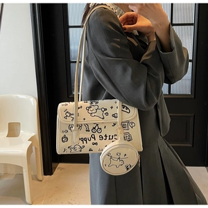 Detalle del bolso de hombro blanco de PU con graffitis de cachorros y un pequeño monedero redondo