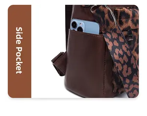 Close-up of leopard print strap and side pocket on brown pebbled leather backpack