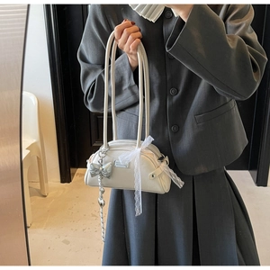 Détail du sac bowling blanc rétro avec nœud en dentelle et pendentif papillon argenté