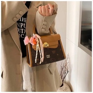 Dettaglio della borsa vintage con chiusura retrò, tela a contrasto e ciondolo rosa