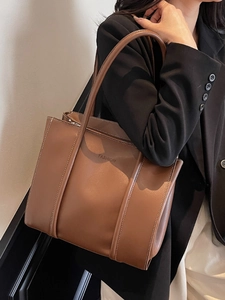 Brown faux leather tote bag with white stitching and fashion text for women