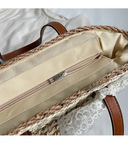 Détail d'un sac cabas en paille avec bordure en dentelle blanche et fermeture éclair en métal