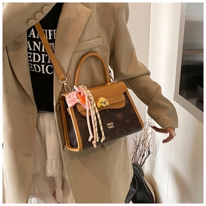 Dettaglio di una borsa a tracolla vintage con chiusura a cane e decorazione con foulard