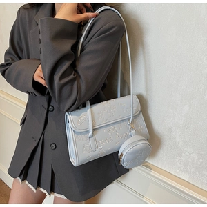 Detalle de bolso de hombro en cuero PU azul claro con lindos motivos grabados