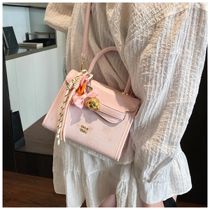 Dettaglio della borsa a tracolla in pelle PU rosa con ciondolo a fiocco e catena in metallo