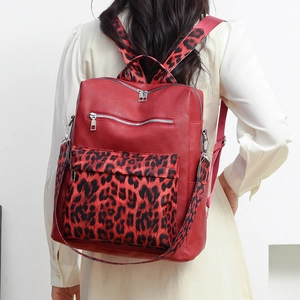 Detail of red leopard print faux fur and leather backpack showing texture and silver zippers