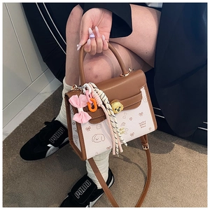Vista dettagliata di una borsa patchwork marrone e beige con simpatica stampa cucciolo