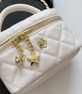 Close-up of quilted cream mini bag featuring gold camellia hardware and star charms