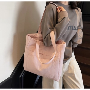 Detail view of pink large-capacity tote bag with wide shoulder strap and front pocket