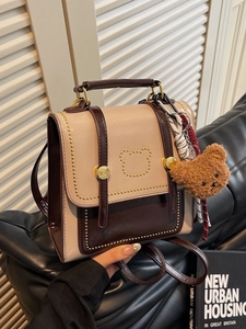 Mini retro leren rugzak met beer stud patroon en pluche bedeltje op leren bank