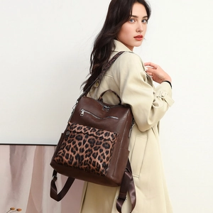 Detail of a brown PU leather backpack with leopard print pockets worn by a model