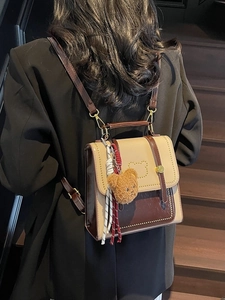 Mini tweekleurige rugzak in collegestijl van PU-leer met bruine berenhanger detail