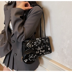 Detalle del bolso de hombro en cuero negro brillante con motivos de grafiti de perros