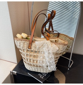 Détail d'un sac cabas en paille tissé avec nœud en dentelle et anses en cuir