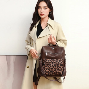 Detail of a brown leather backpack featuring a stylish leopard print front pocket
