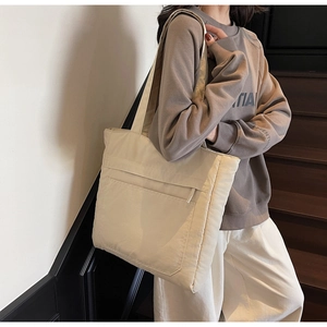 Detail of off-white oversized tote bag with horizontal zip pocket for daily commuting