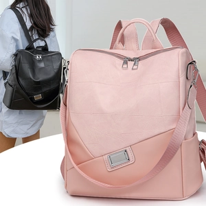 Dettaglio di zaini rosa e neri con design patchwork geometrico e logo metallico