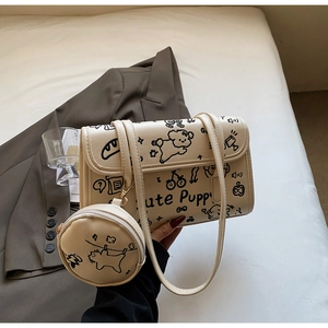 Detalle del bolso de hombro beige con grafitis de perritos y monedero redondo