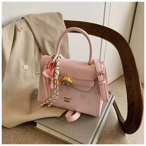 Dettaglio della borsa in pelle rosa con chiusura a cane dorata e sciarpa di seta