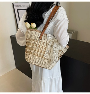 Détail du sac cabas en paille avec nœud en dentelle blanche et touches florales