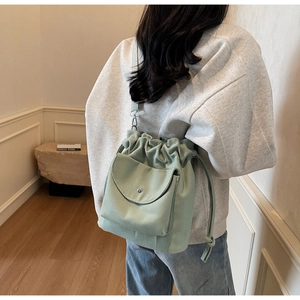 Borsa a secchiello in tela verde salvia con coulisse e tasca frontale con bottone argento